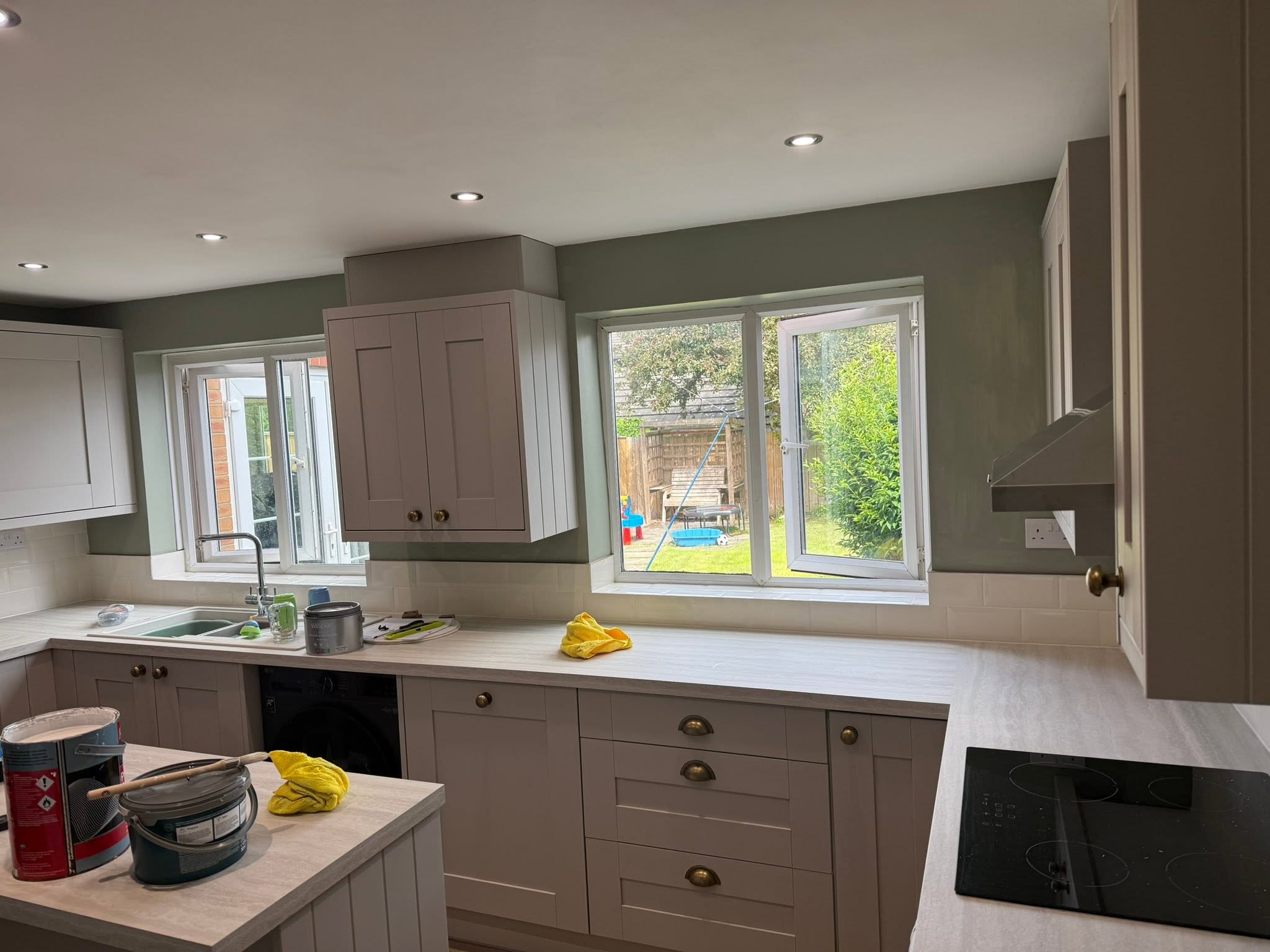 Newly fitted shaker kitchen with sage green walls