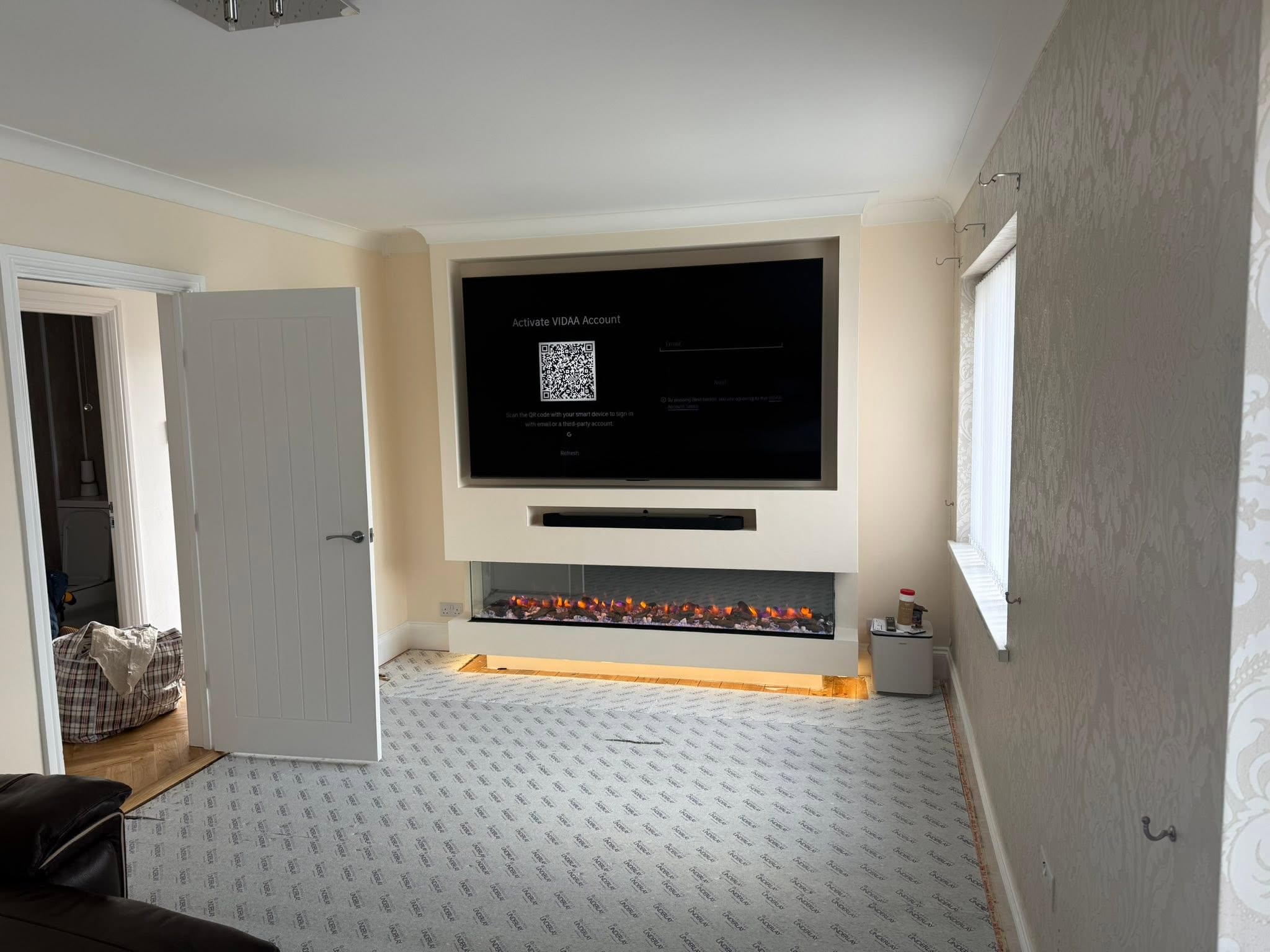 Living room with fitted window blinds and media wall